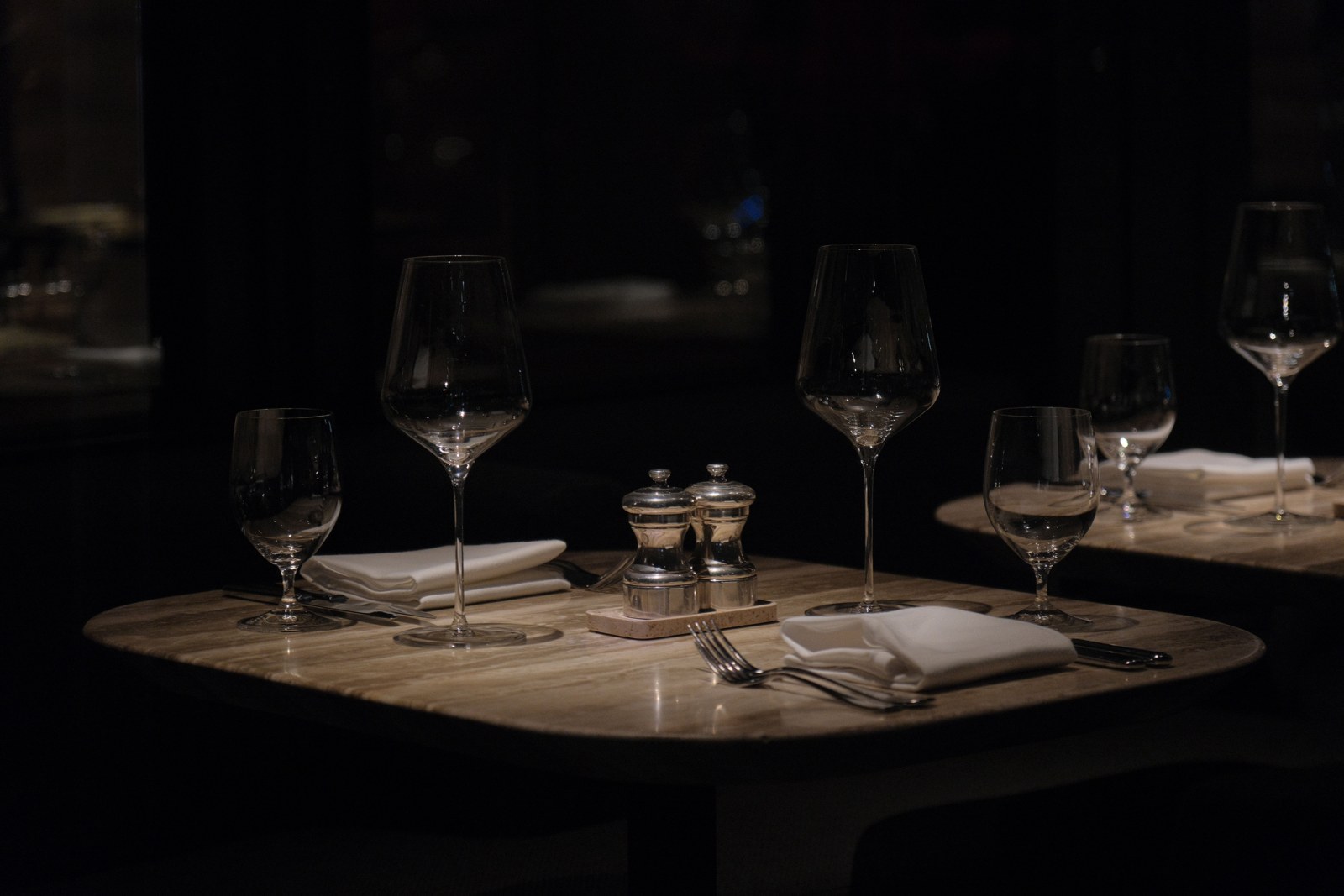 Dining — a table set for two, crystal, low light.