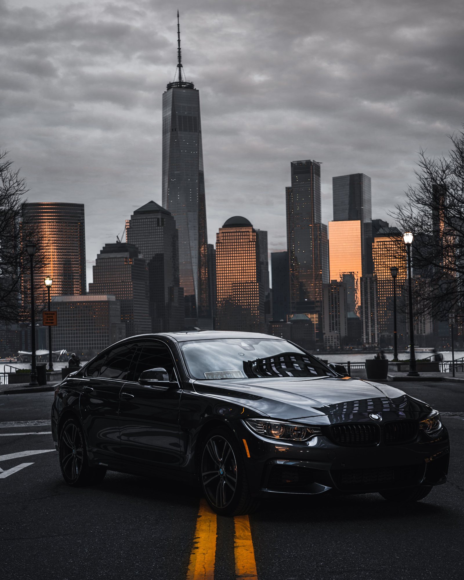 Drivers & Security — a dark sedan, Lower Manhattan at sunset.
